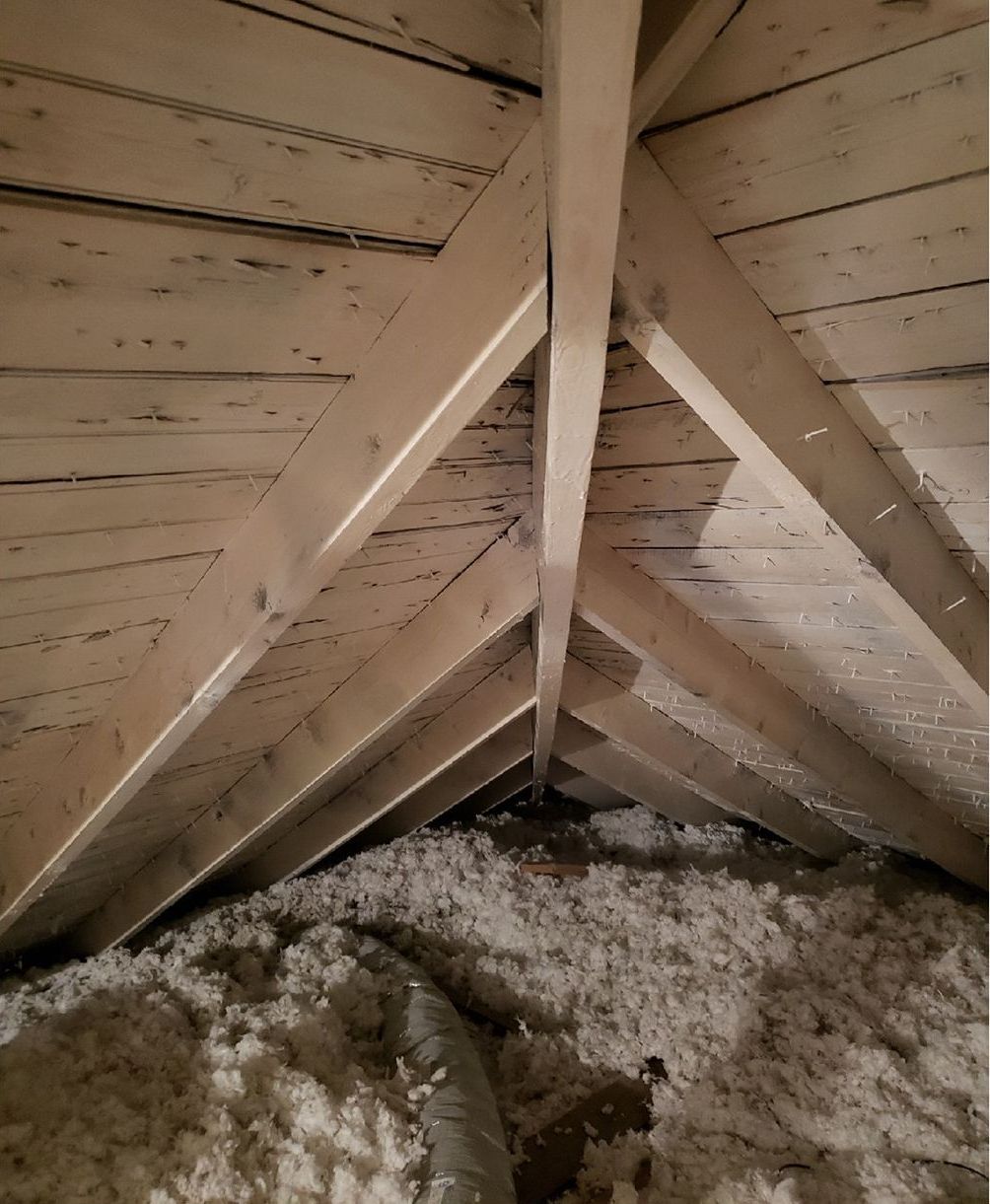 There is a lot of insulation in the attic of a house.