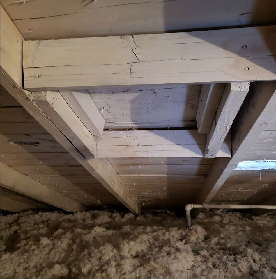 A ceiling with a lot of wooden beams and insulation