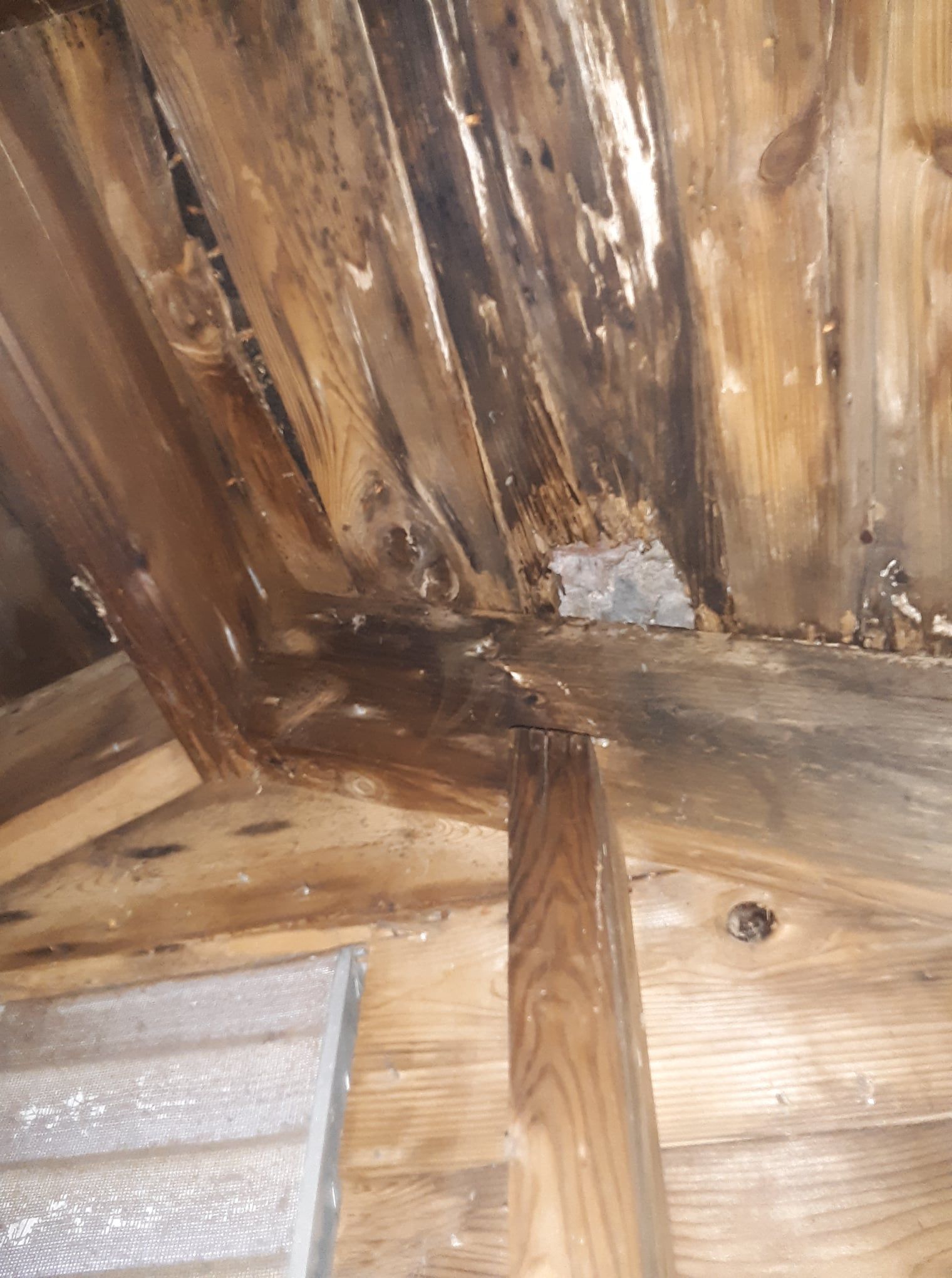 A close up of a wooden ceiling with a hole in it.