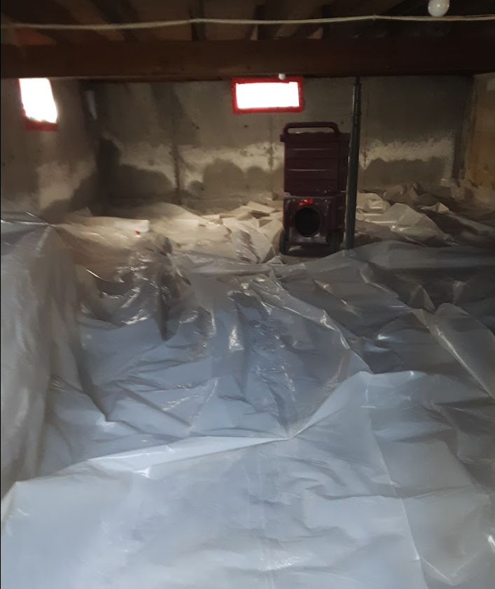A basement with a lot of plastic covering the floor.