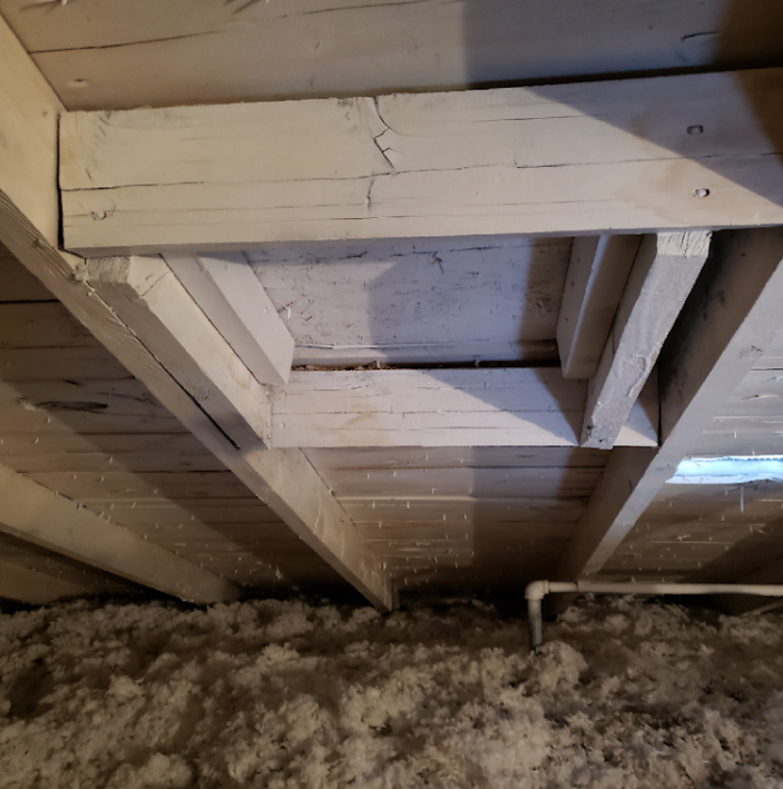 A ceiling with a lot of wooden beams and insulation