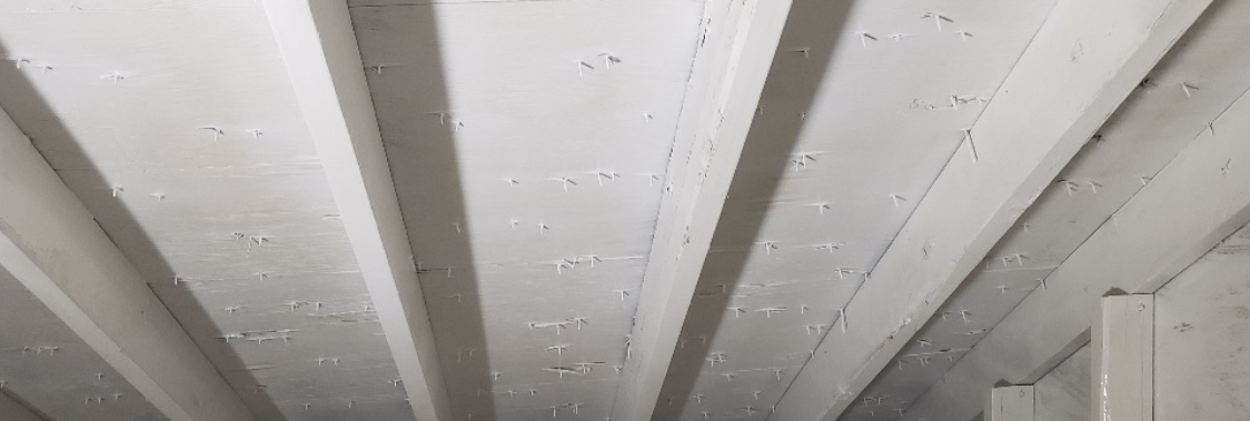 A close up of a white wooden ceiling in a room.