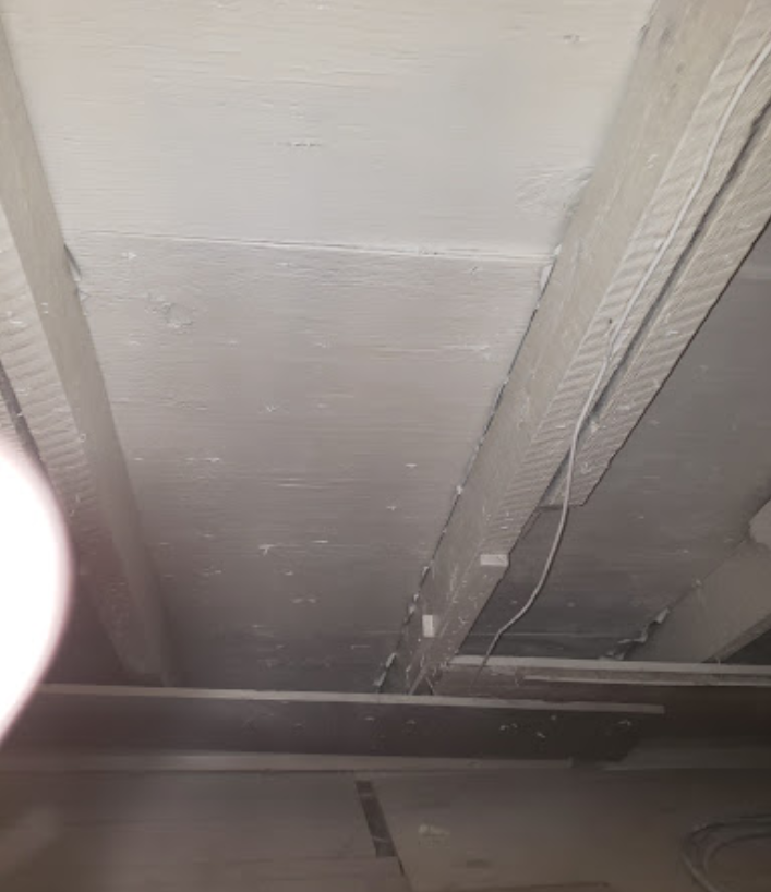 A close up of a ceiling with a light hanging from it.