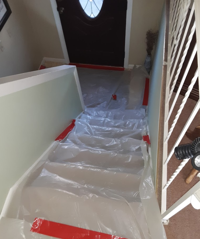 The stairs are covered in plastic and red tape