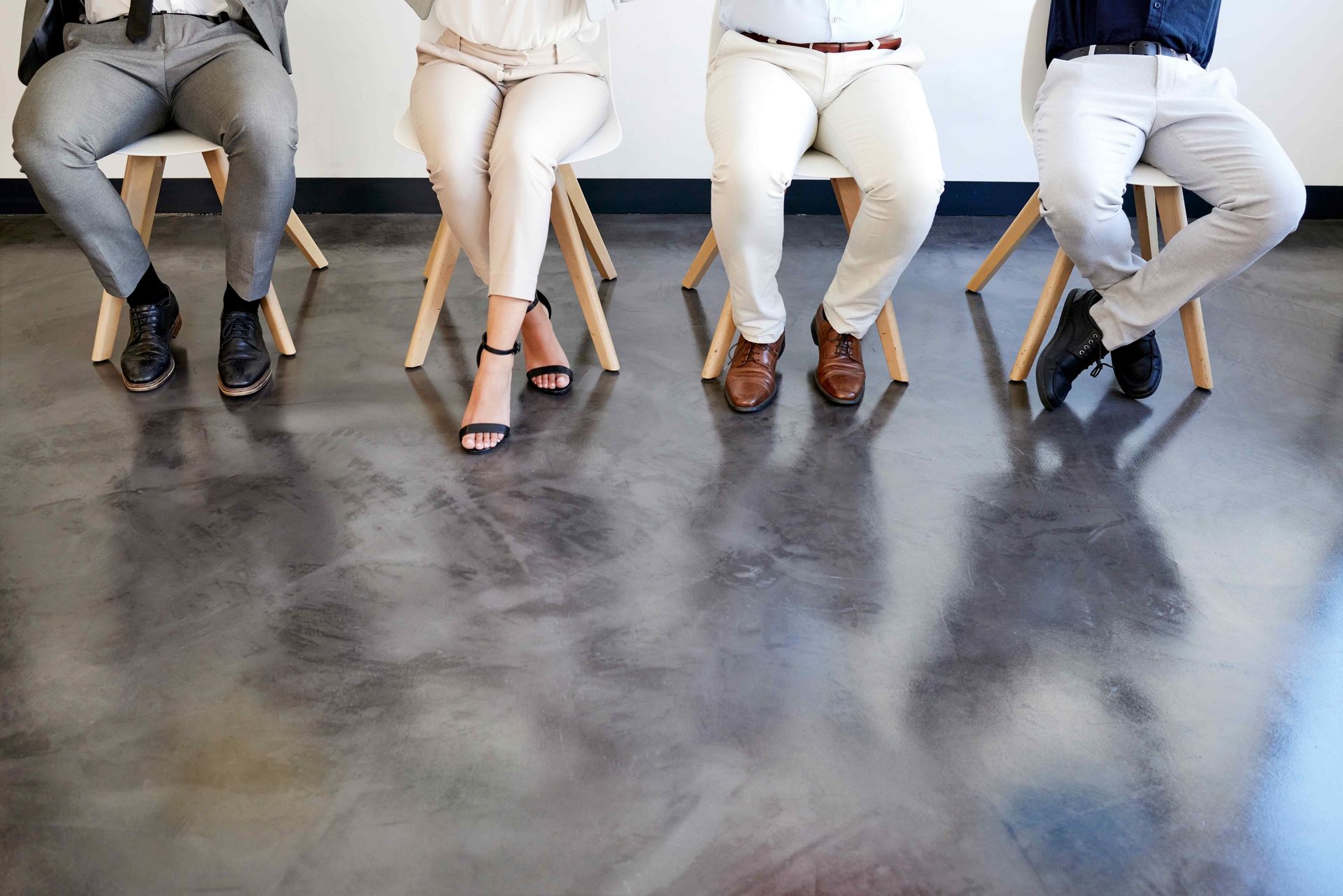 Business People Sitting On Chairs On Stained Concrete Floor