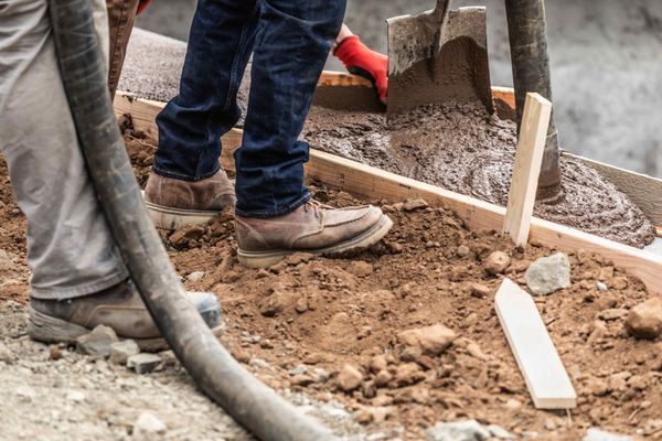 Expert Concrete Workers Pouring Concrete Into Wooden Frame