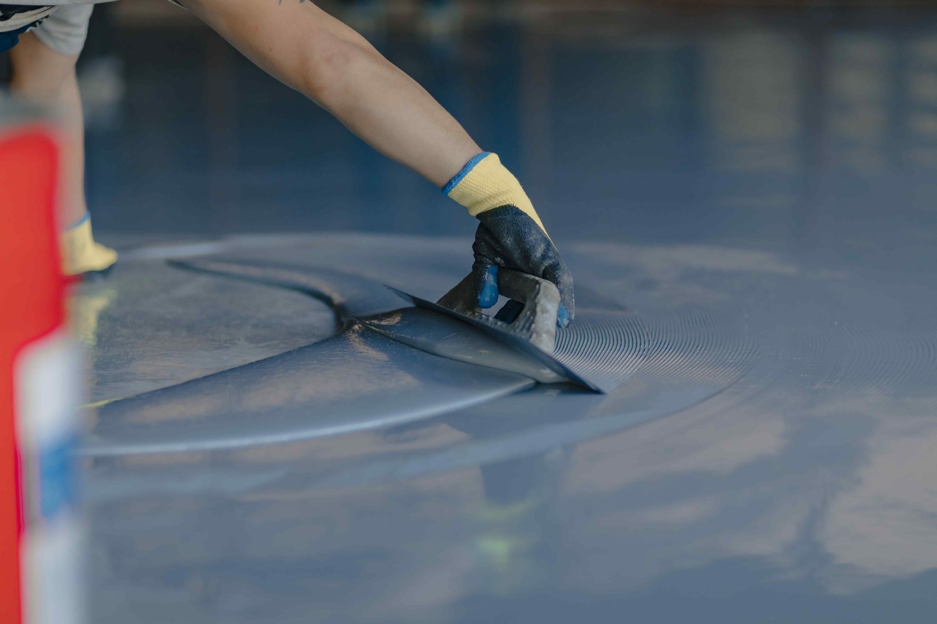 Worker Applies Blue Gray Epoxy Resin To Concrete Floor