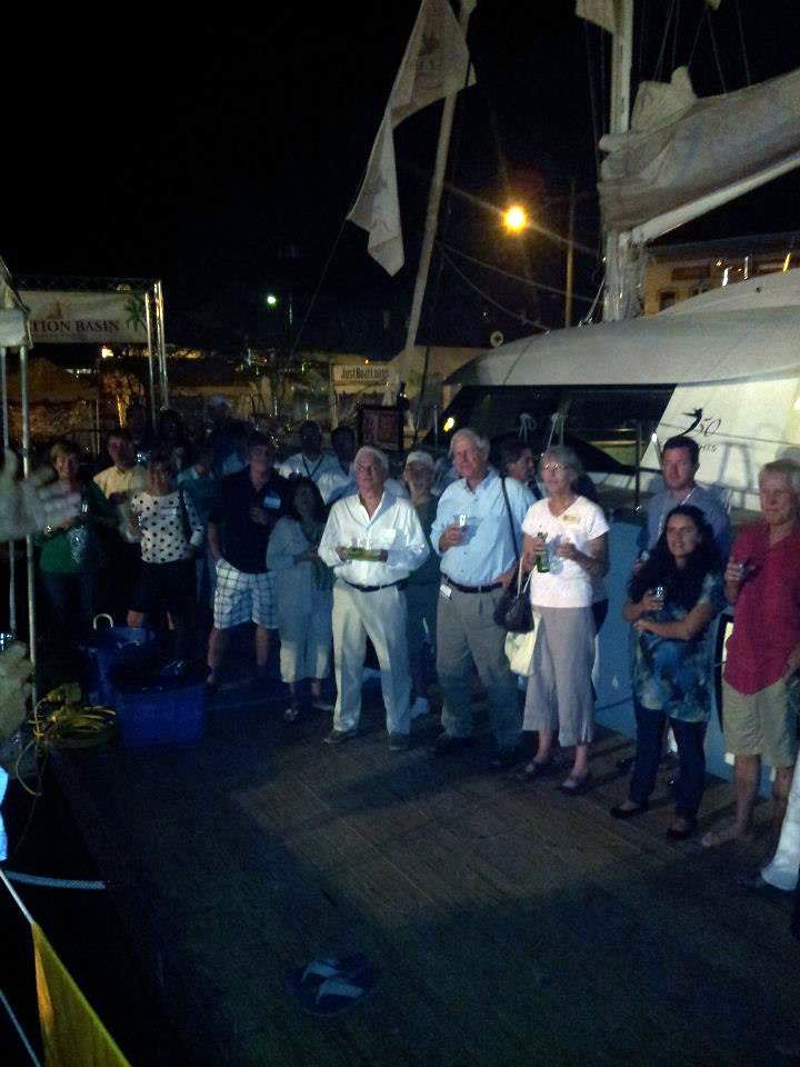 A group of people standing in front of a boat at night