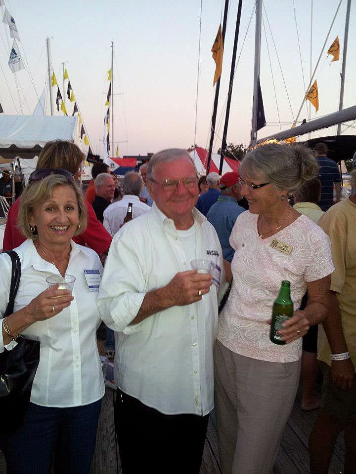 A man and two women standing next to each other holding drinks
