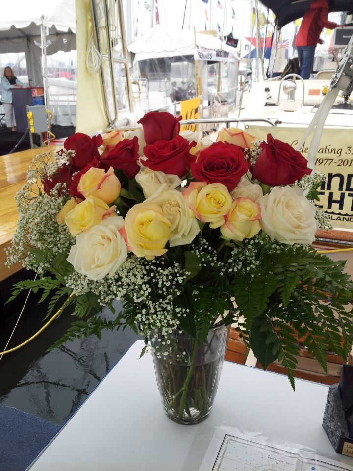 A vase filled with red and yellow roses sits on a table