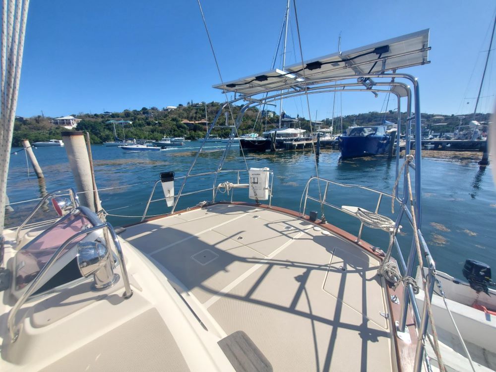 A sailboat is docked in a harbor with boats in the water.