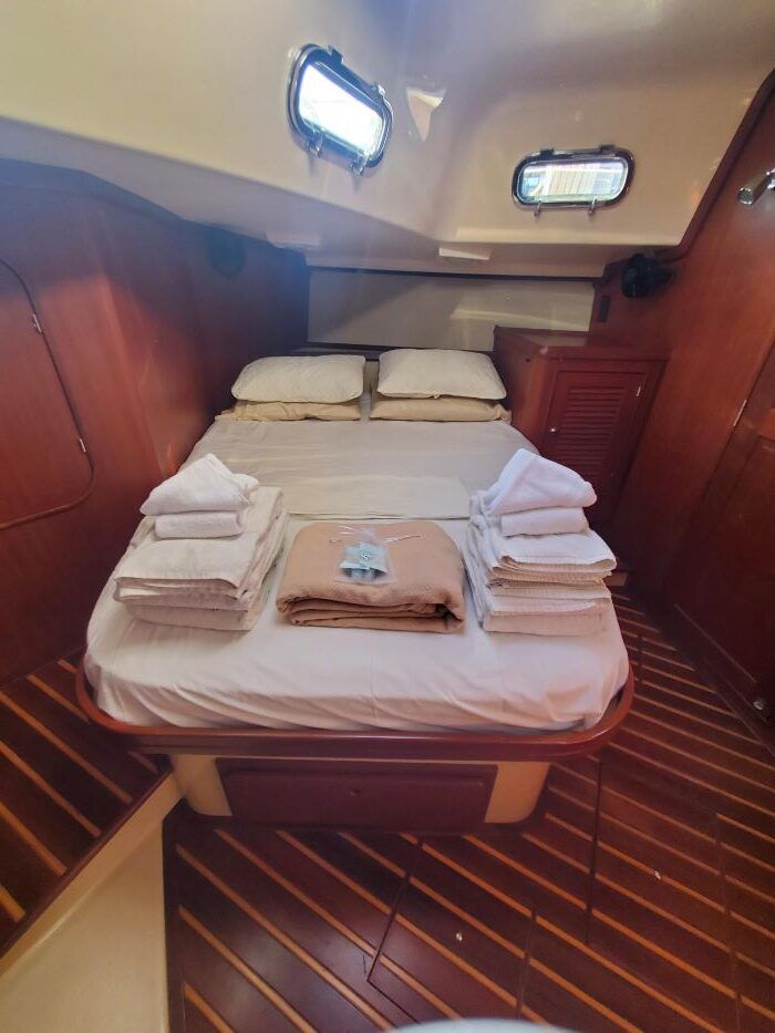 A bedroom on a boat with a bed and a window.