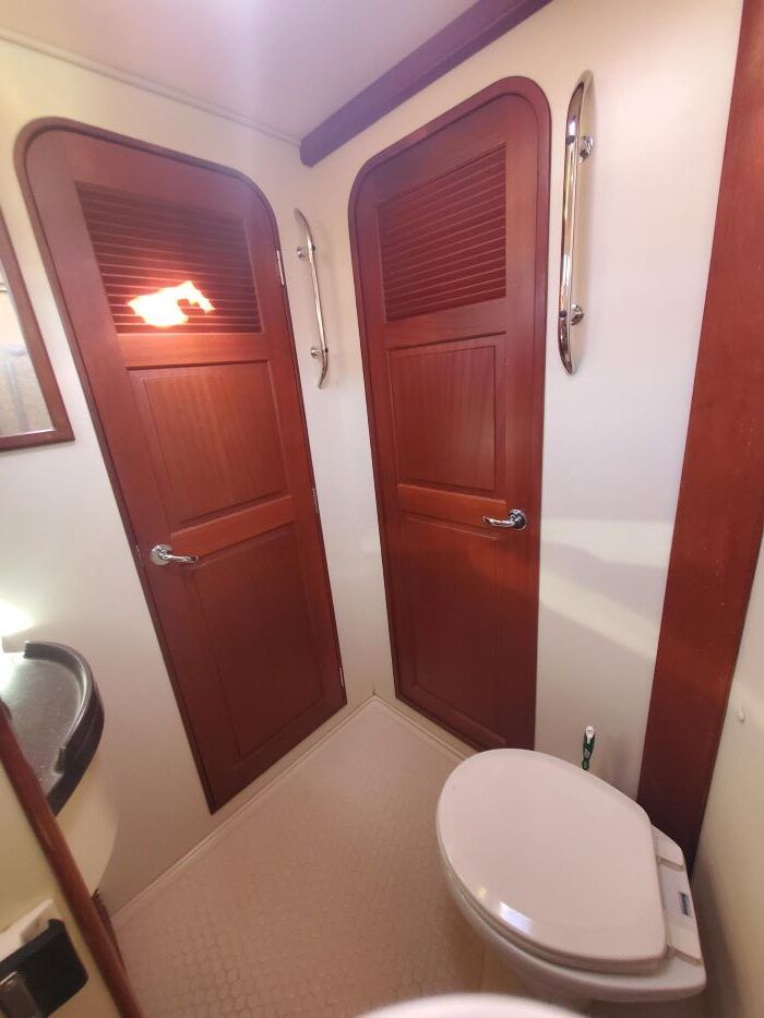A bathroom with two wooden doors and a toilet