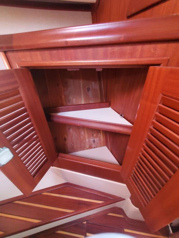 The inside of a wooden cabinet with shutters on the doors