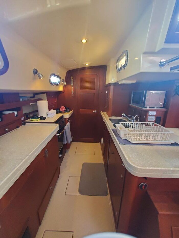 A kitchen on a boat with a sink and a microwave.
