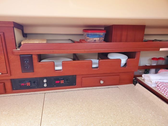 A wooden bunk bed with a shelf and drawers underneath it.
