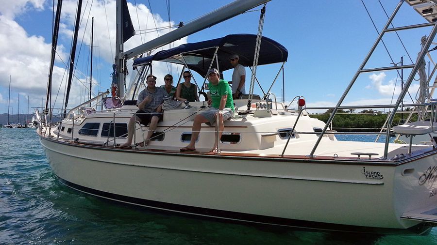 A group of people are sitting on a sailboat in the water.