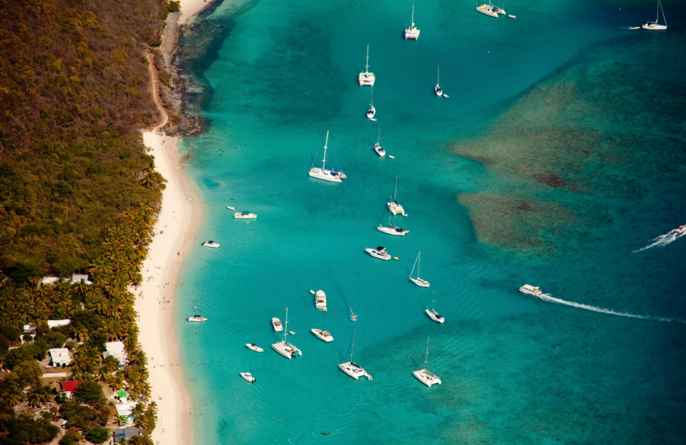The British Virgin Island from above featuring sailboats off the coast of the beach.