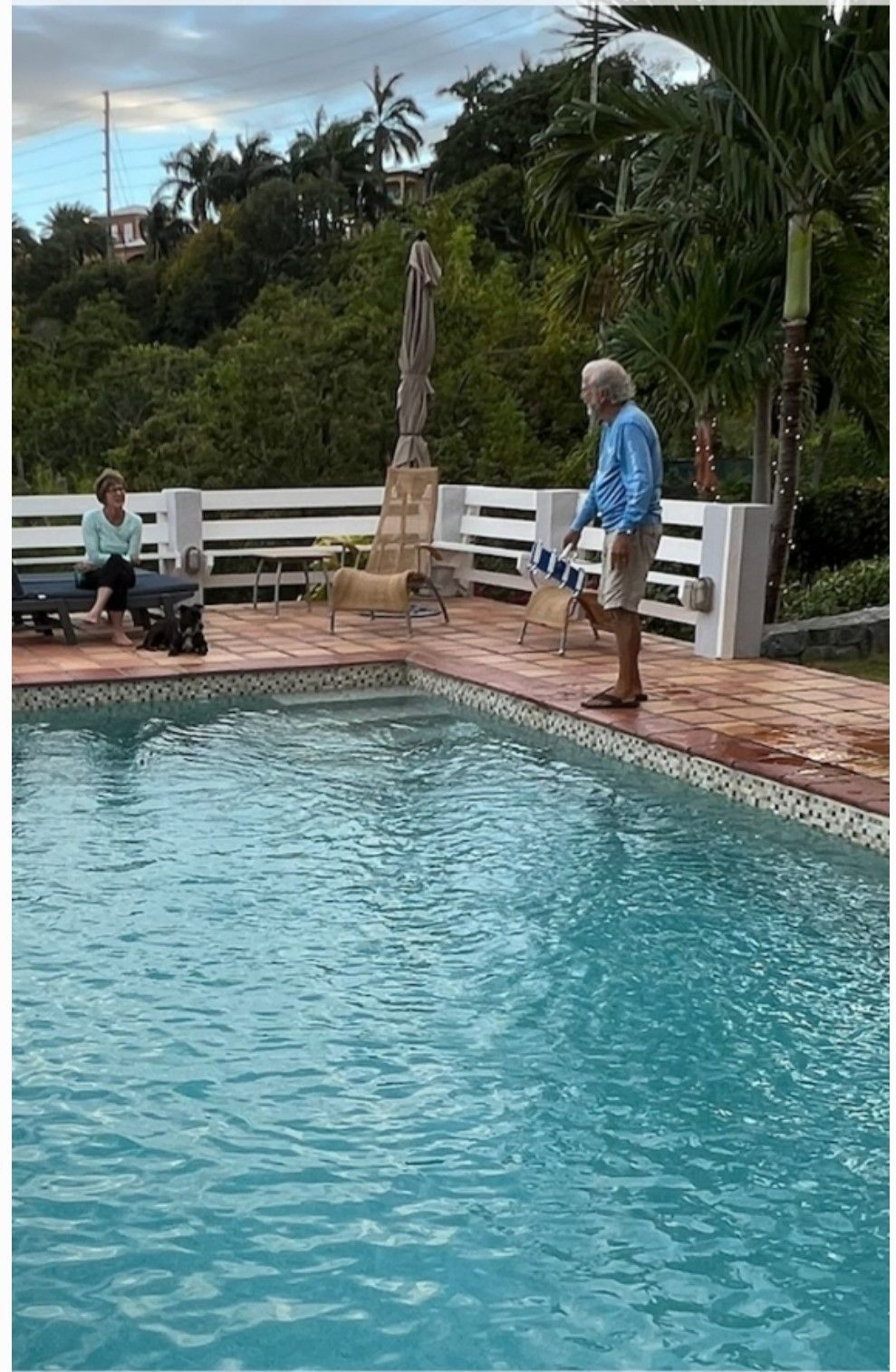 A man is standing on the edge of a swimming pool.