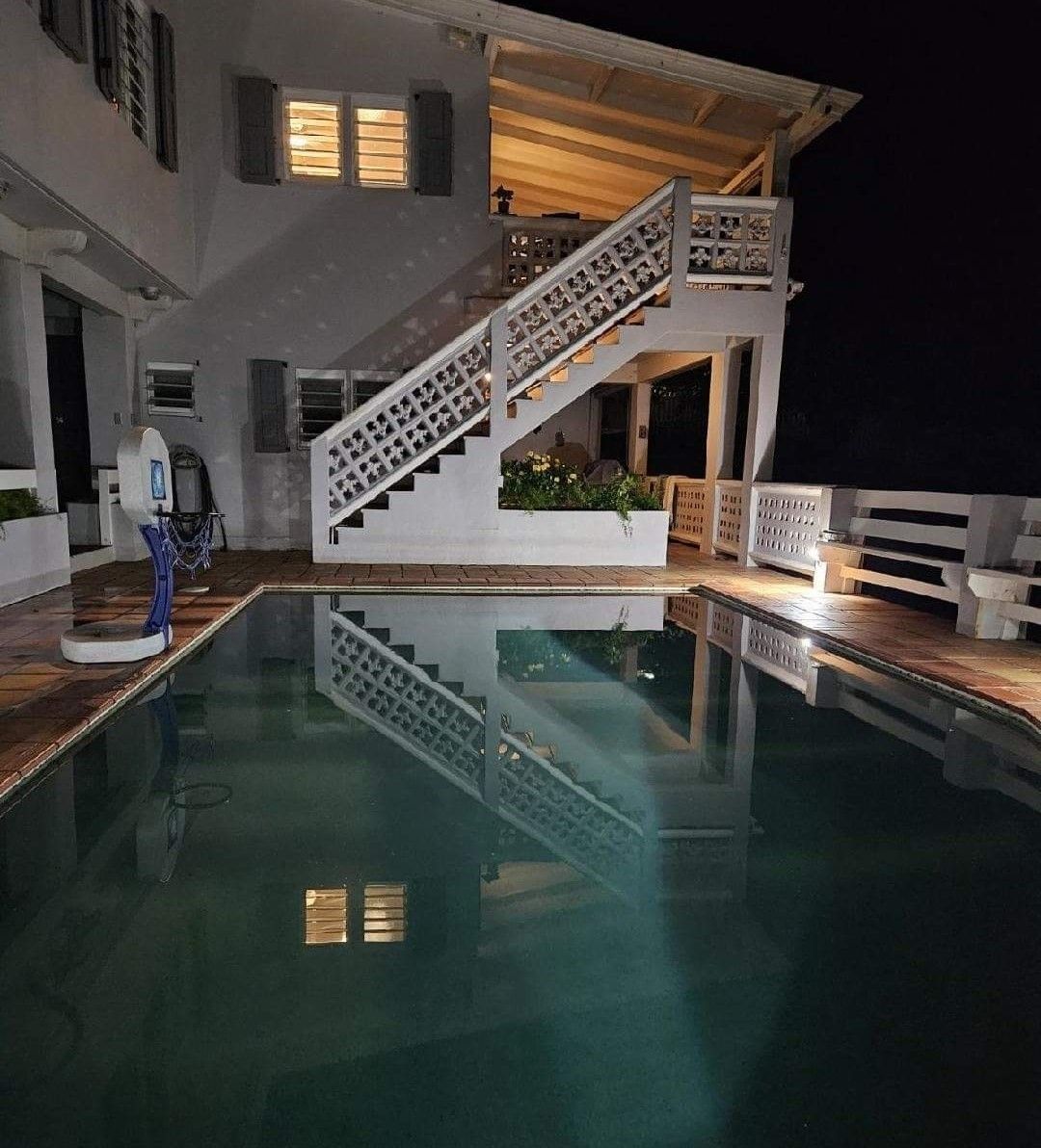 A large white house with a swimming pool in front of it