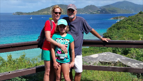 A family posing for a picture with the ocean in the background