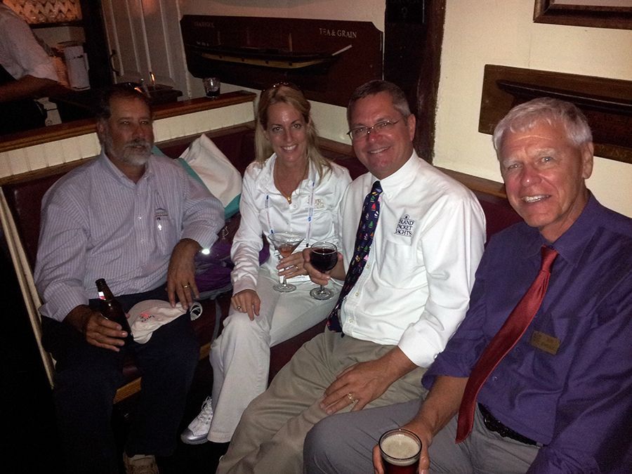 A group of people are sitting on a couch drinking wine