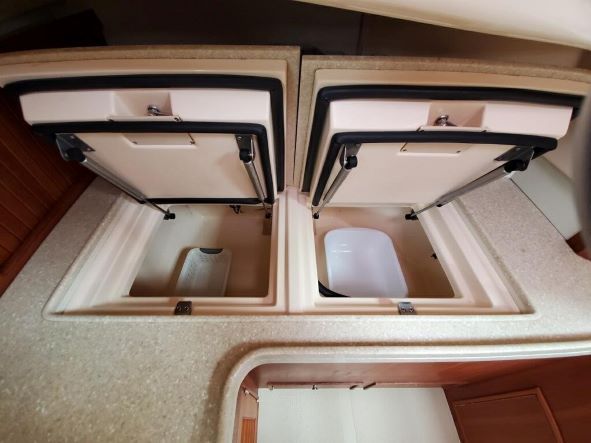 A boat with two coolers and a toilet in it