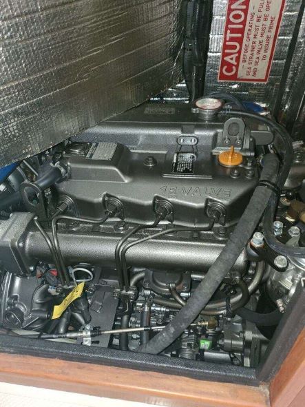 A close up of a boat engine with a caution sign in the background