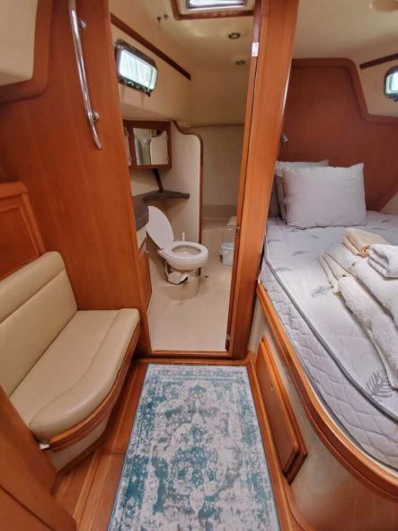 A bedroom on a boat with a bed and a toilet