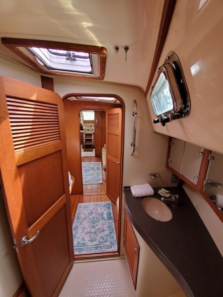 A bathroom on a boat with a sink and a door open