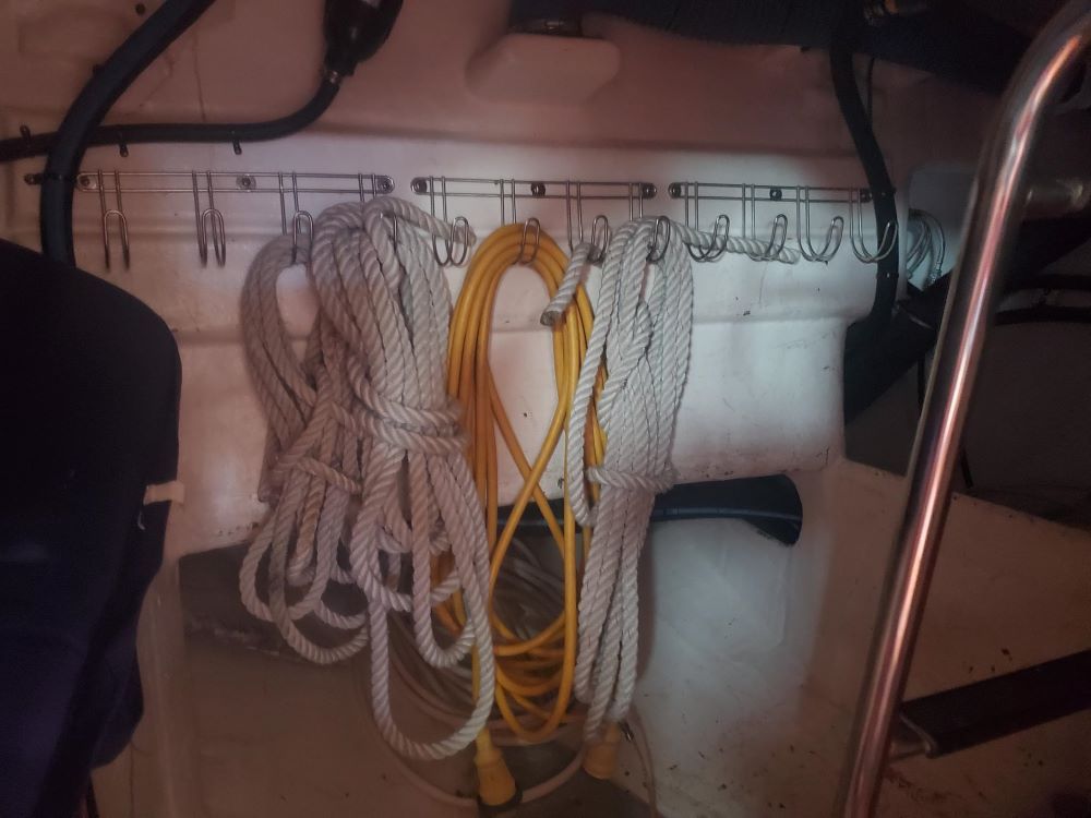 A bunch of ropes are hanging from hooks on a wall