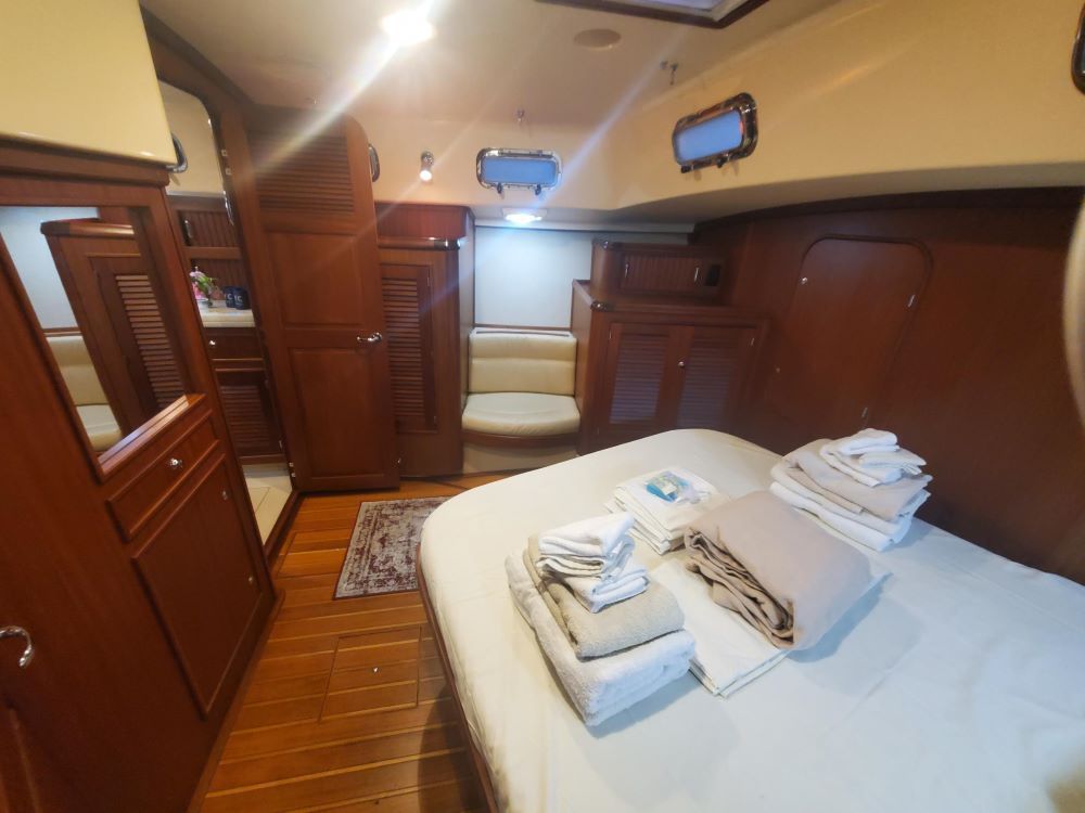 A bedroom on a boat with a bed and a mirror