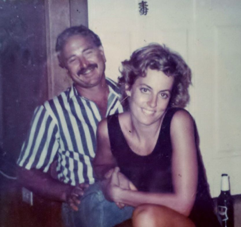 A man in a striped shirt is sitting next to a woman in a black tank top