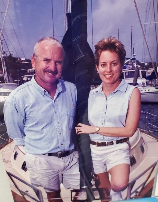 A man and a woman are posing for a picture on a boat