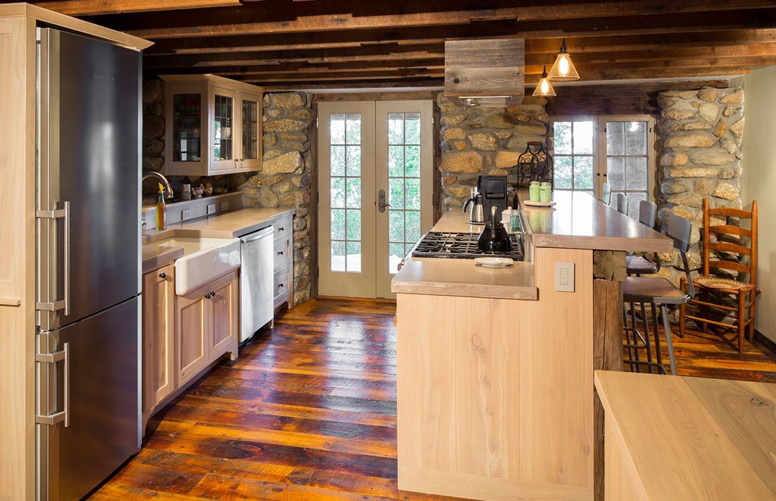 A kitchen with wooden floors and stainless steel appliances.
