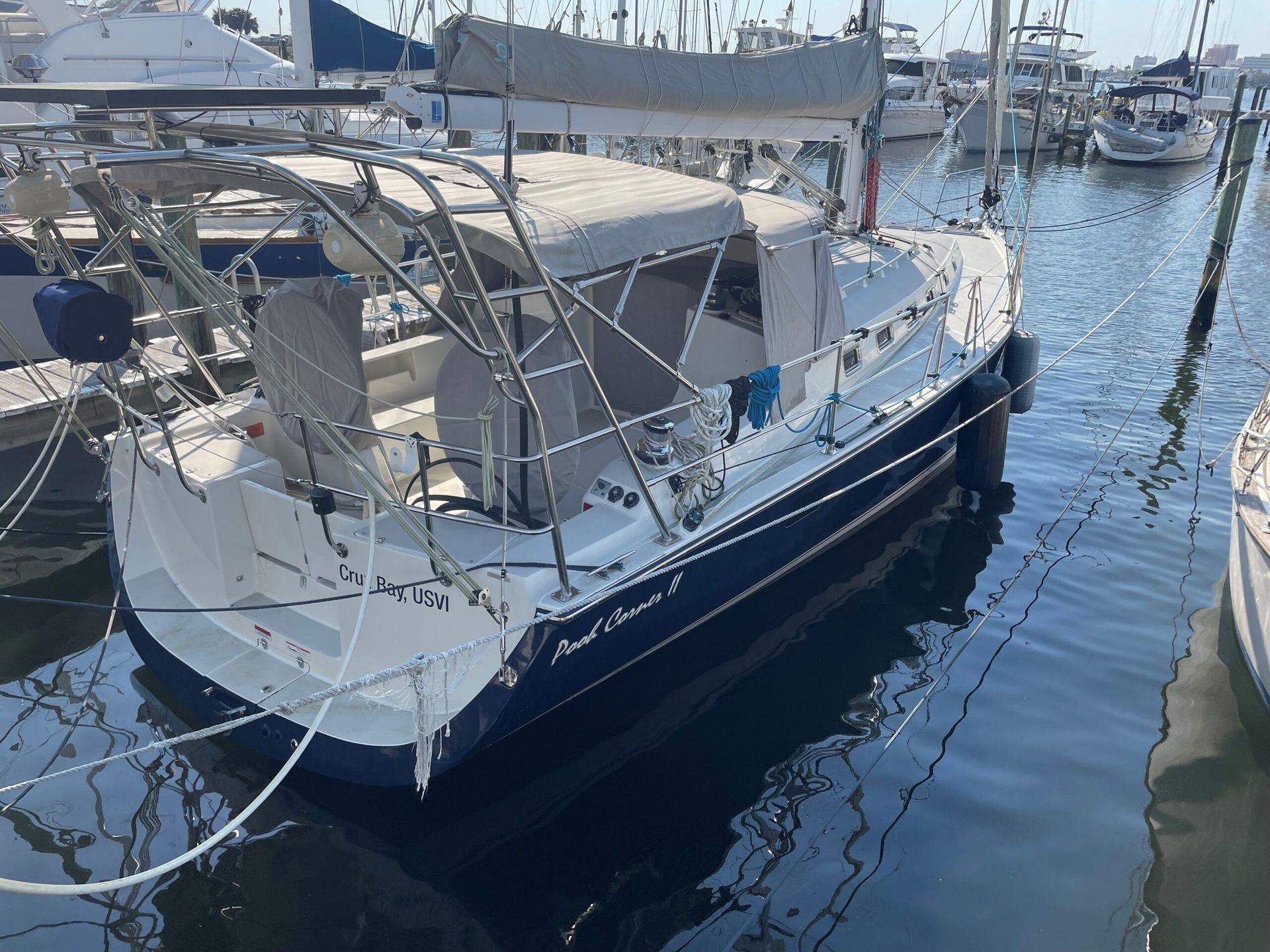 A sailboat is docked in a marina with other boats.