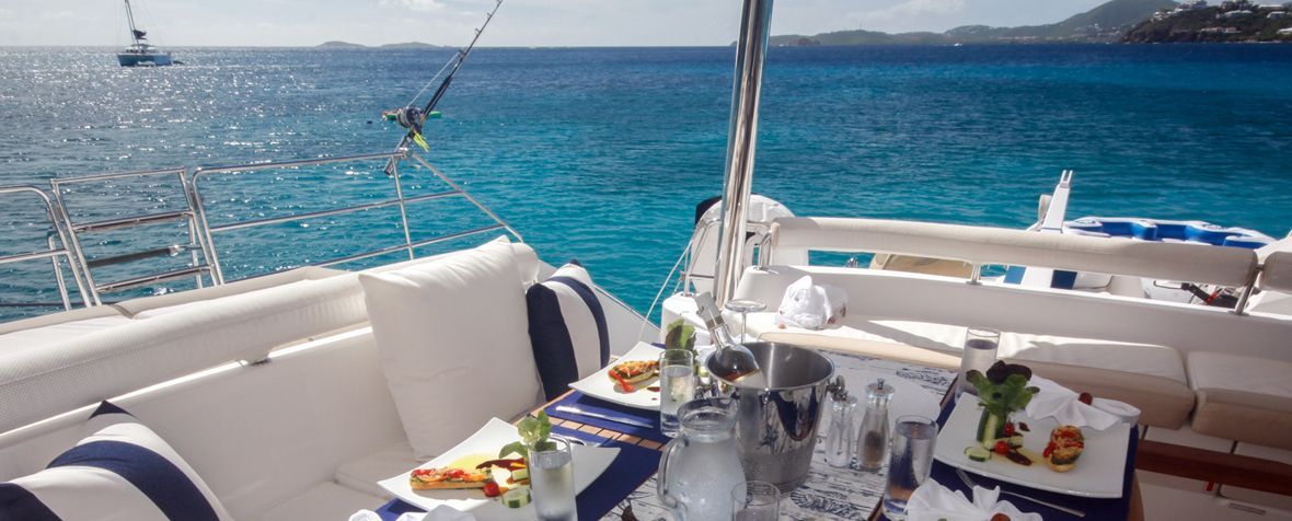 There is a table set up on the back of a boat in the ocean.