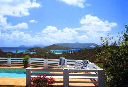 A swimming pool with a view of the ocean and mountains.