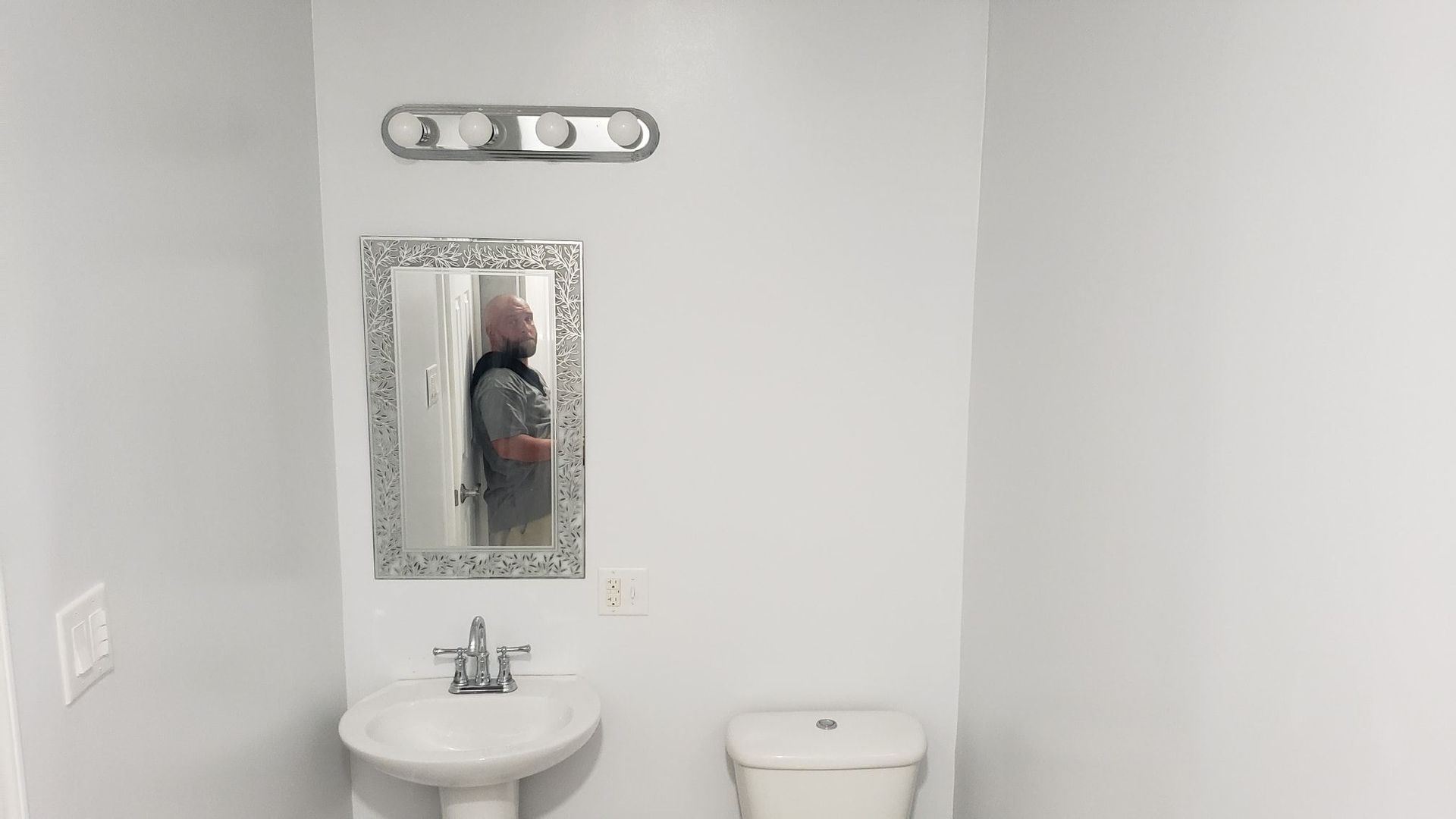A bathroom with a sink , toilet and mirror.