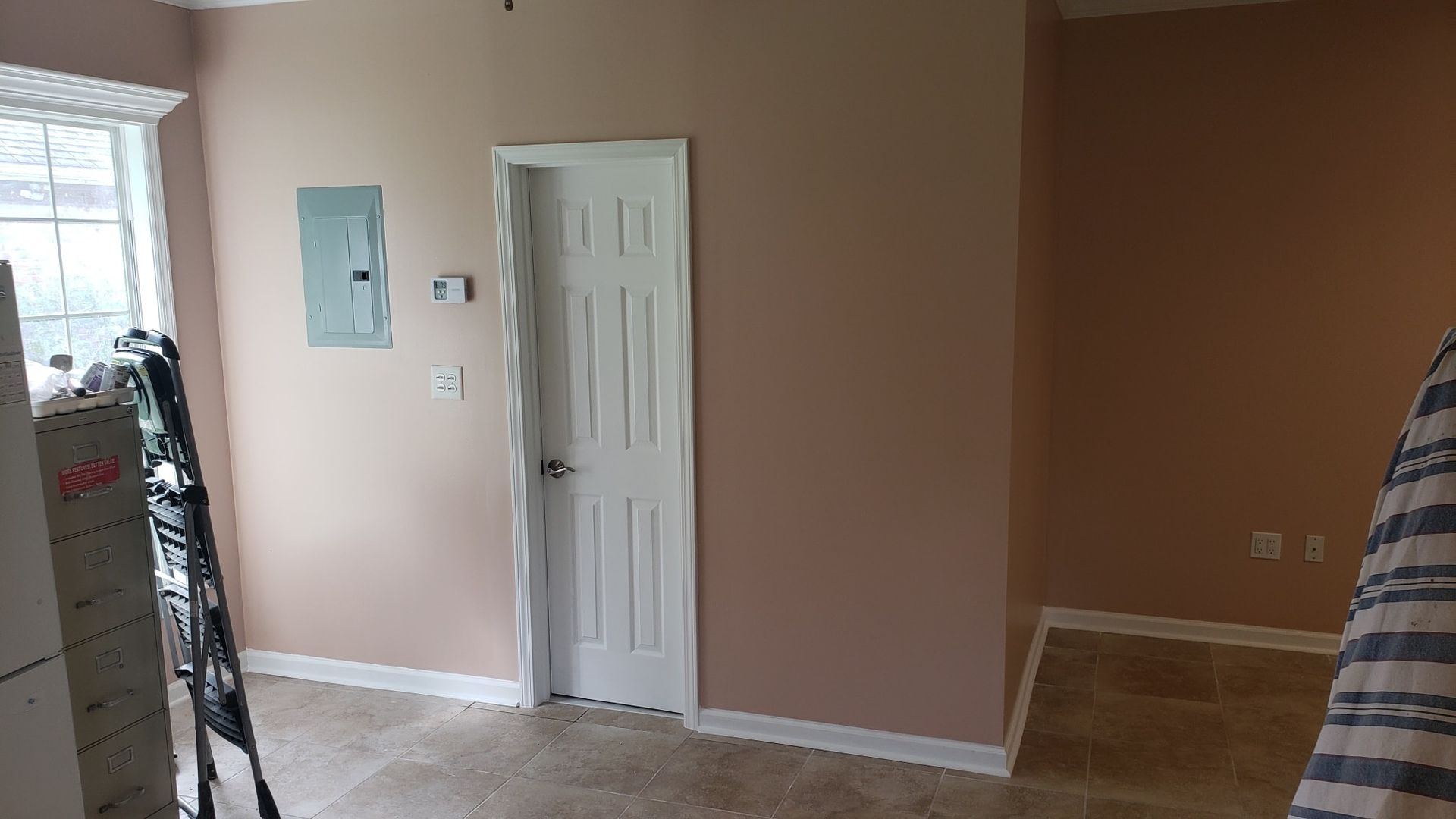 A room with pink walls and a white door.