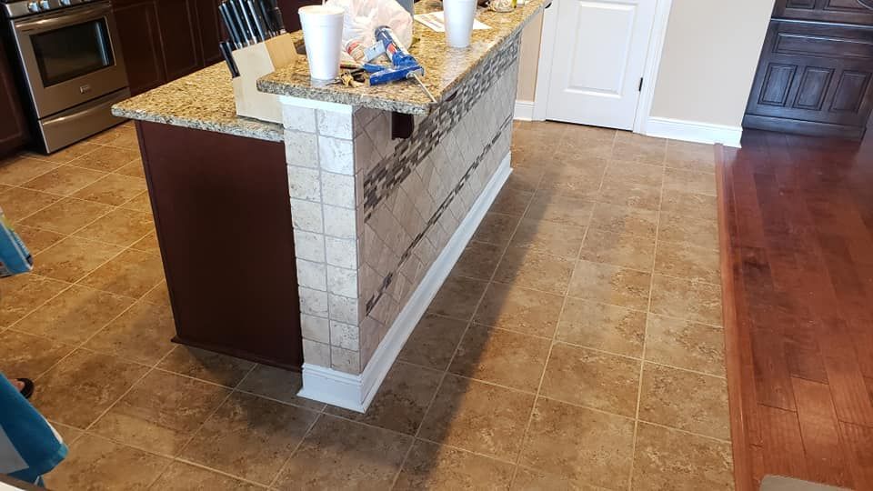 A kitchen with a large island and a wooden floor.