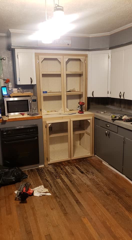 A kitchen with wooden cabinets and hardwood floors is being remodeled.
