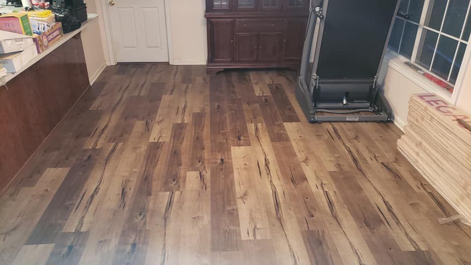 A room with a wooden floor and a treadmill in it.