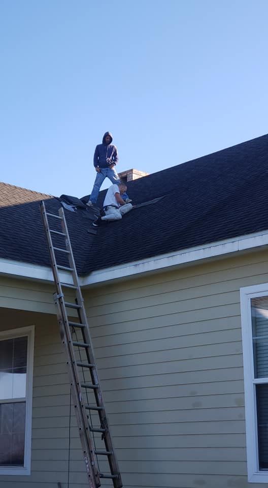 A man is standing on top of a ladder on the roof of a house.