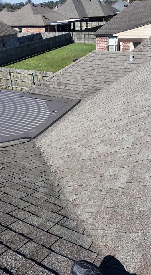 A person is standing on the roof of a house.