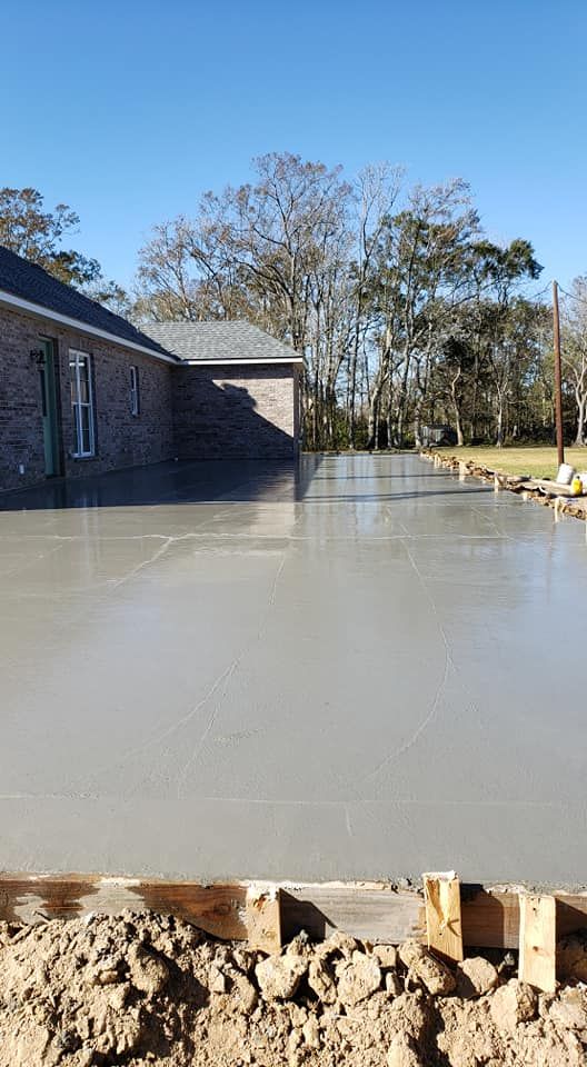 A concrete driveway is being built in front of a house.