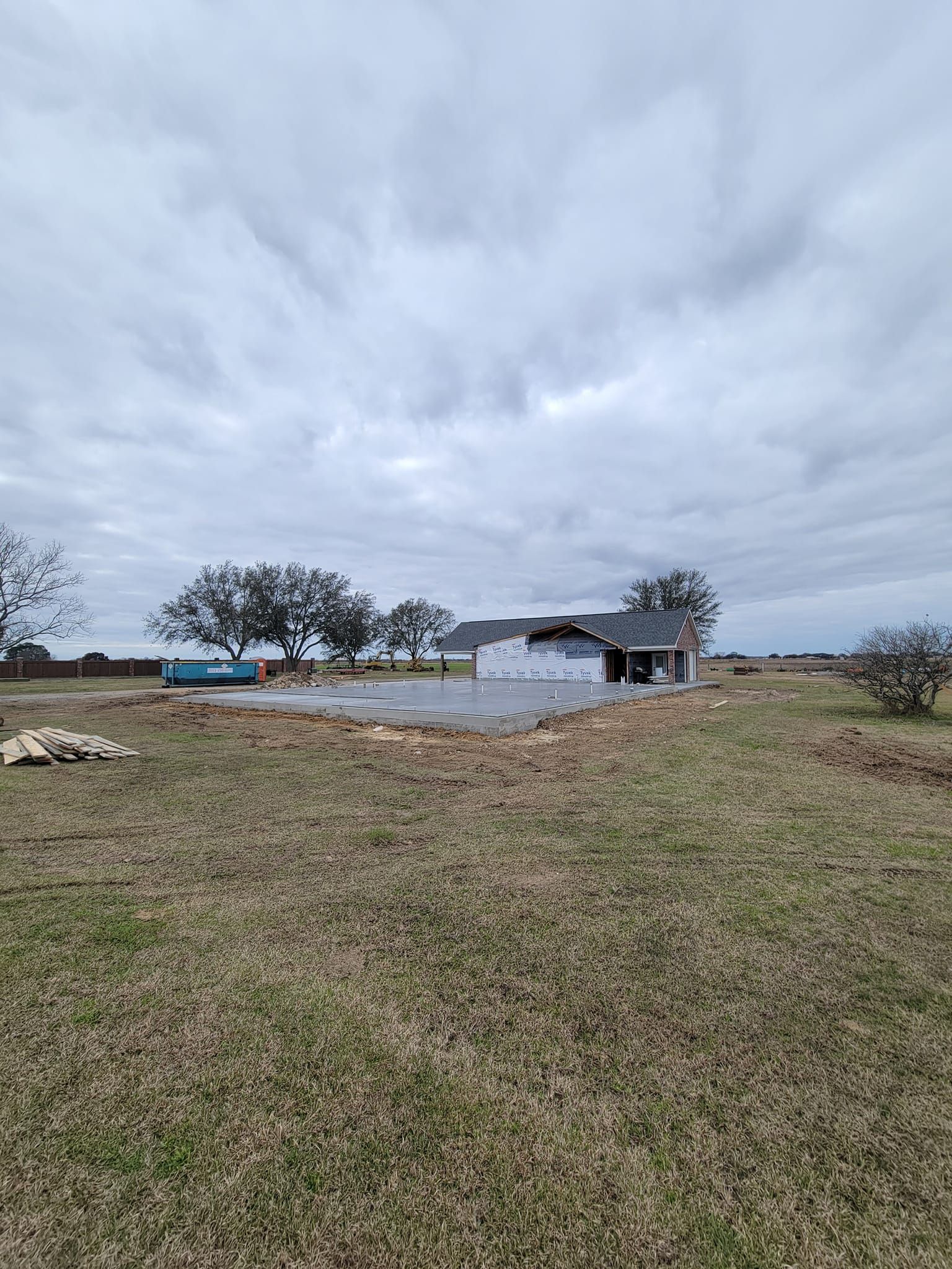 A house is being built in the middle of a grassy field.