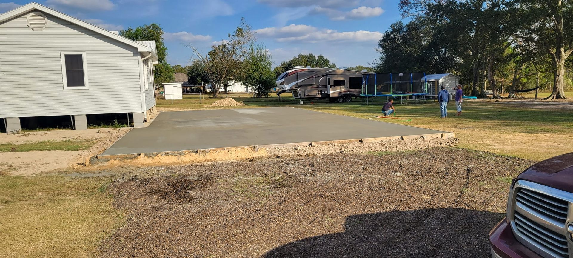 A truck is parked in front of a house and a concrete driveway.