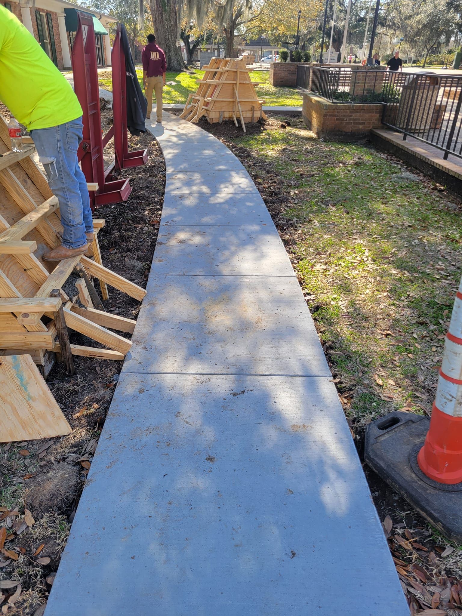 A concrete walkway is being built in a park.