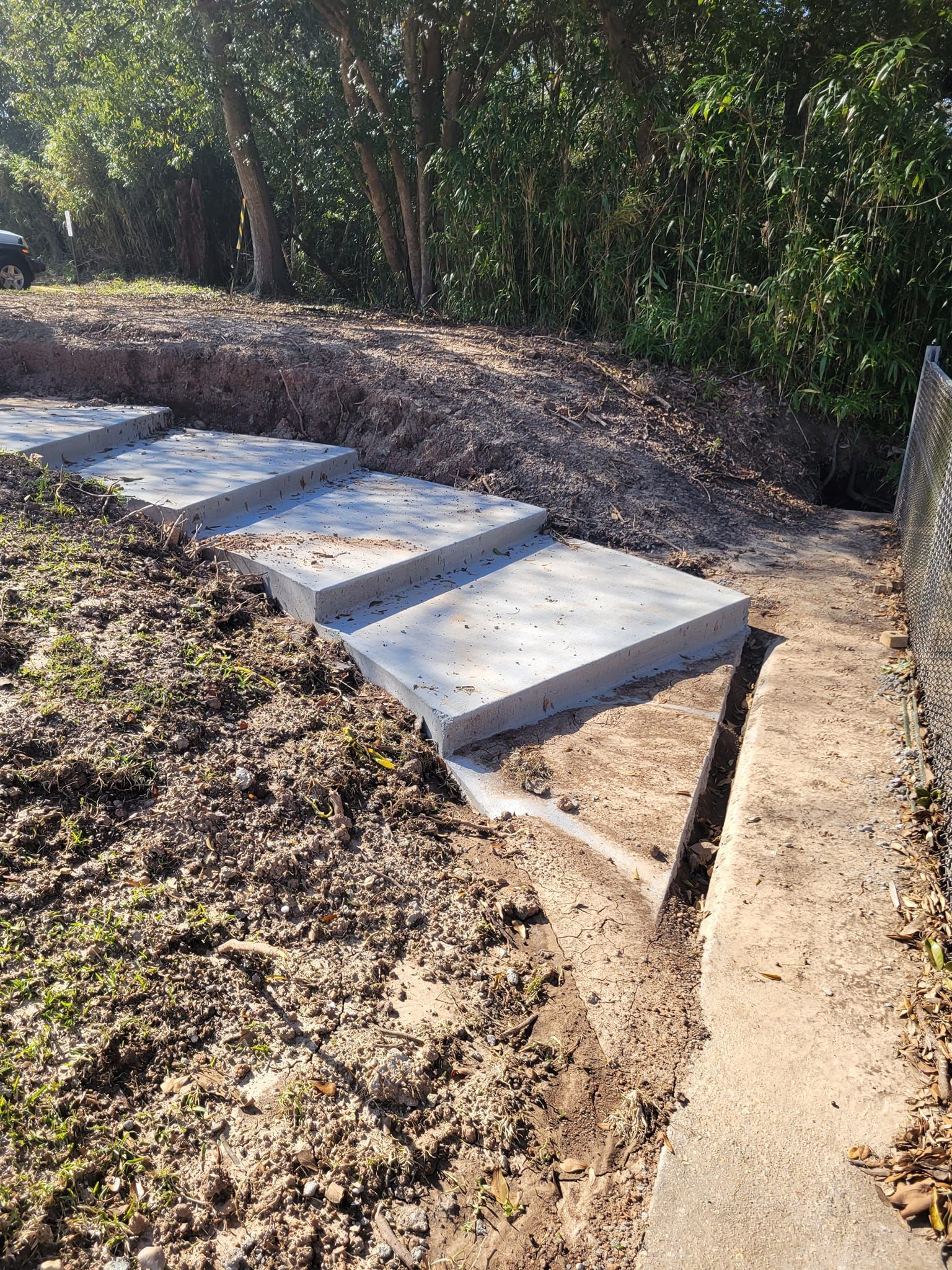 A concrete walkway is being built in the middle of a dirt field.